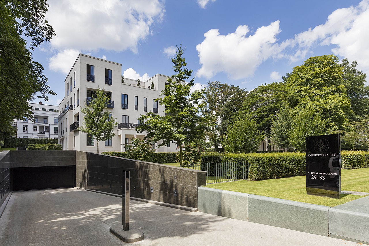 Ramp to the underground car park beside a neat lawn, address stele with house numbers 29–33 and residential buildings