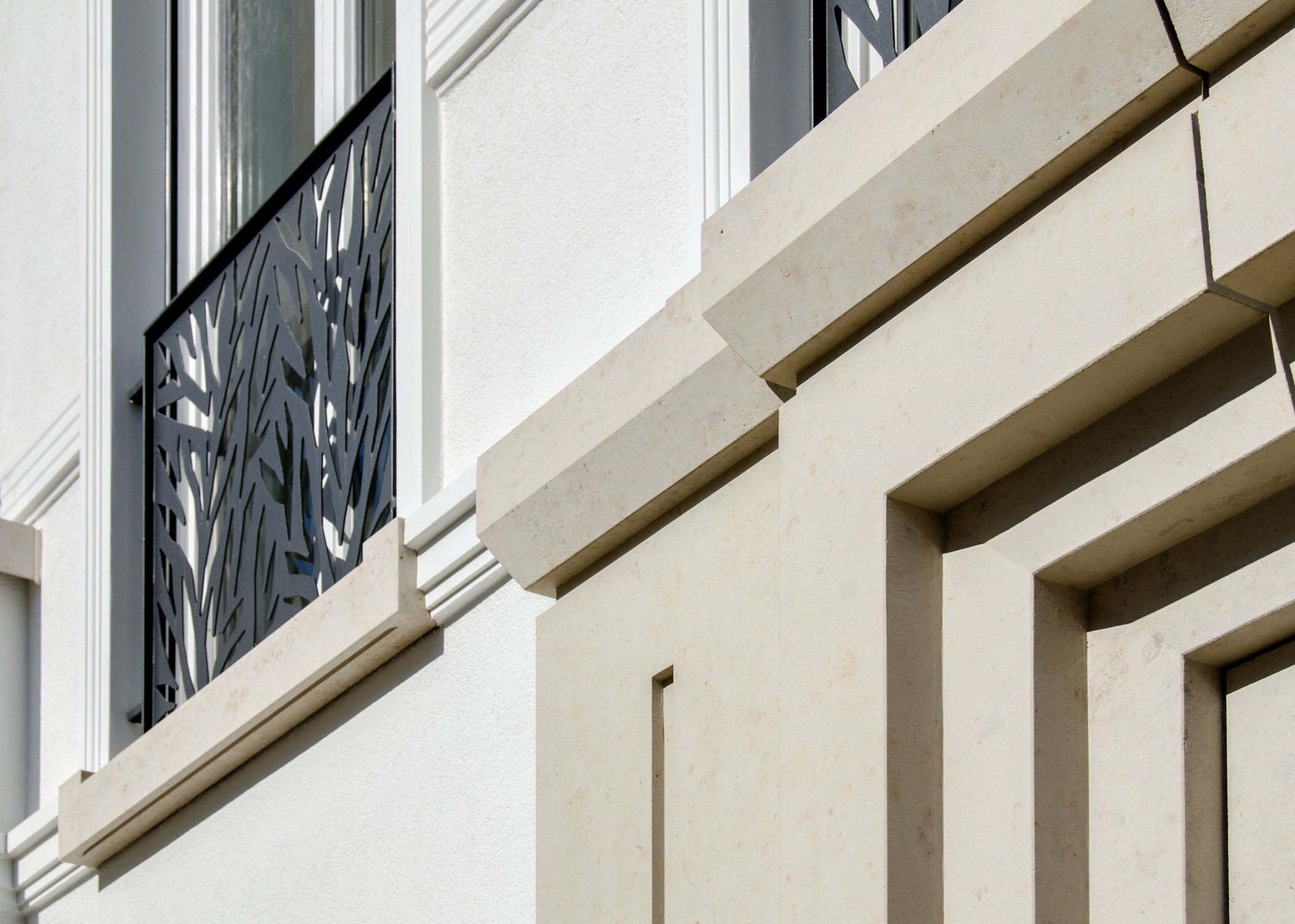 Detailansicht der Parkvillen der Sophienterrassen mit hellen Natursteinfassaden und kunstvoll gestalteten Metallgeländern einer modernen Luxuswohnung