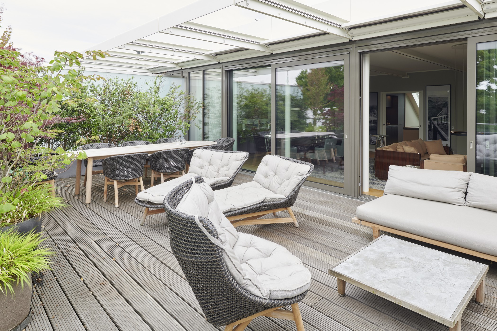 Heller Wohn- und Essbereich der Sophienterrassen in Hamburg Harvestehude mit Blick auf die großzügige Terrasse und hochwertige Designer-Möbel