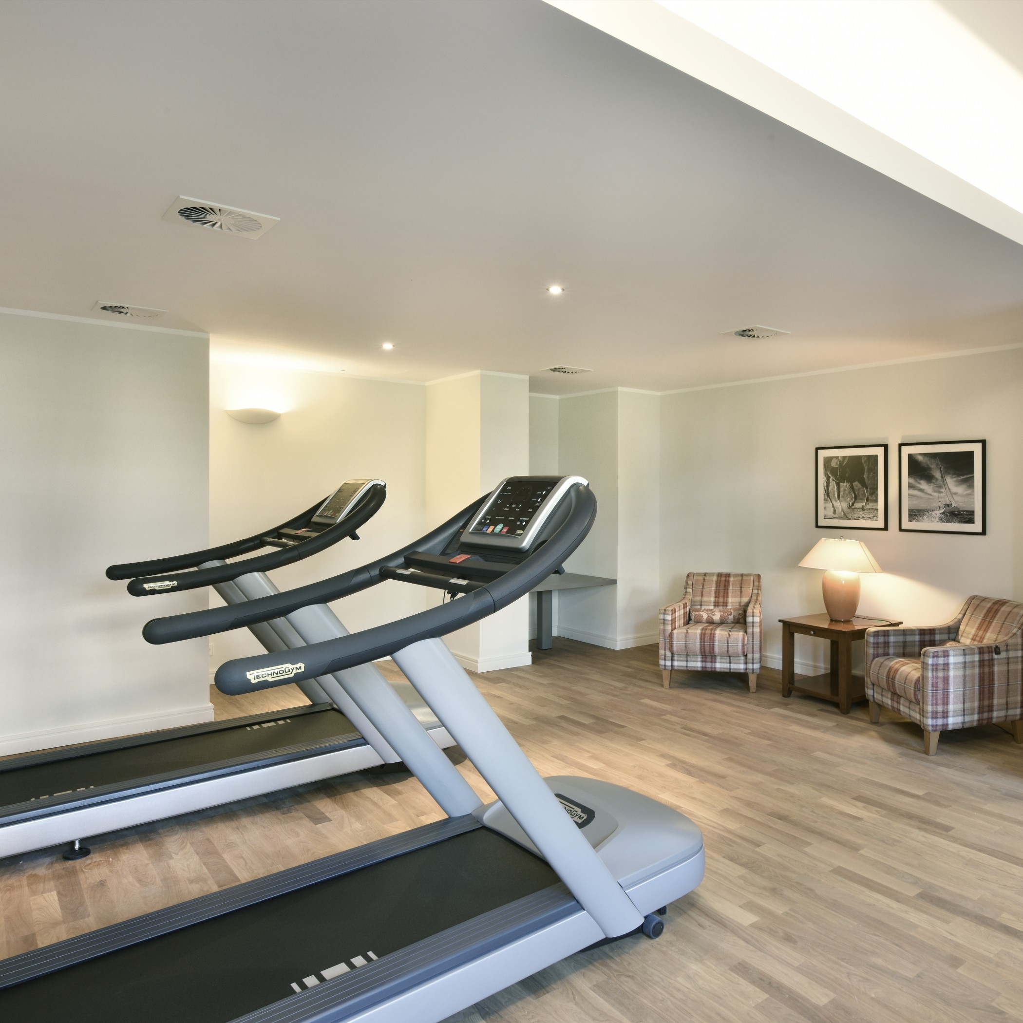 Fitnessbereich der Sophienterrassen in Hamburg Harvestehude mit modernen Laufbändern und gemütlicher Loungeecke