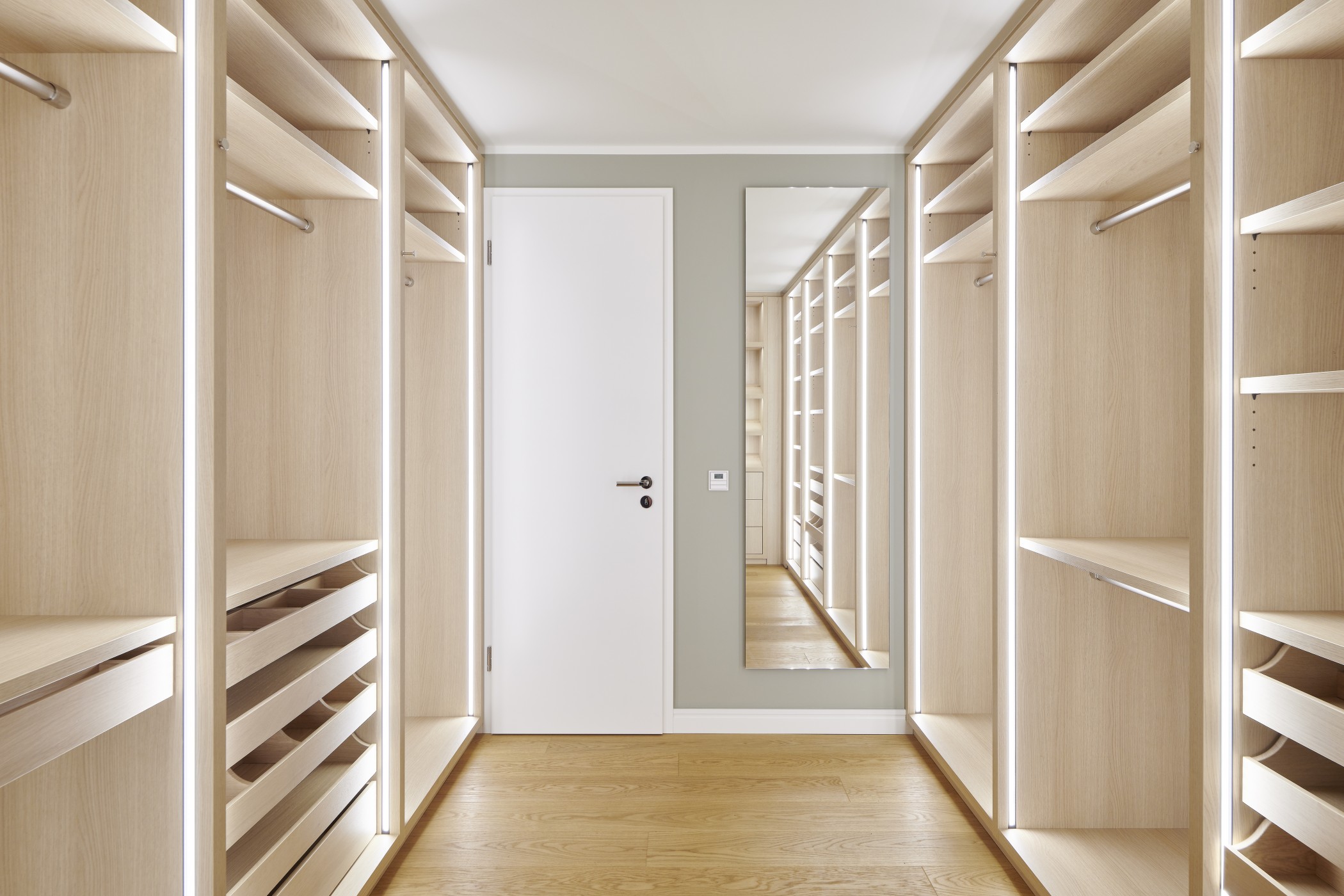 Helles Ankleidezimmer der Sophienterrassen in Hamburg Harvestehude mit maßgefertigten Einbauschränken und elegantem Lichtkonzept
