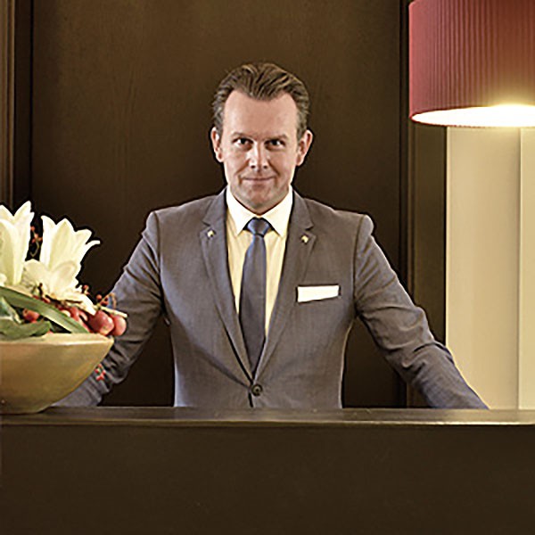 Concierge-Service der Sophienterrassen in Hamburg Harvestehude mit elegant gekleideter Empfangsperson an der Rezeption